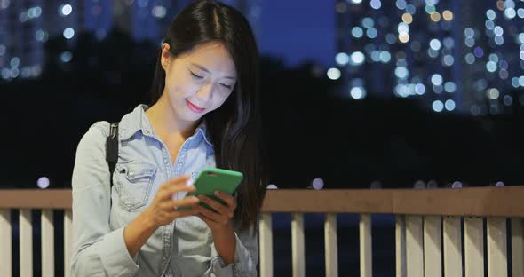 Woman looking at mobile phone in the evening