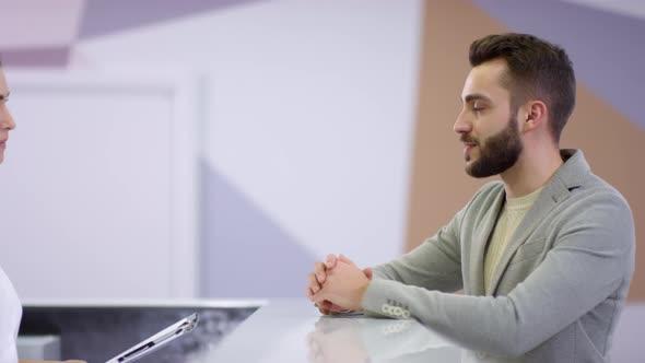 Man Taking Patient Registration Form at Hospital Reception