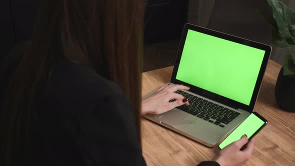 Closeup Woman Typing on Laptop Green Screen on the Table with Phone Chromakey