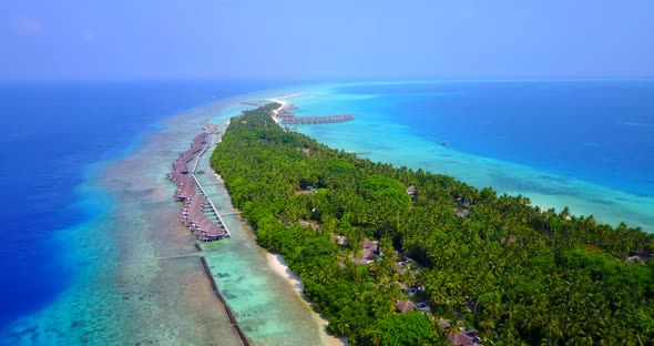 Natural above travel shot of a white sandy paradise beach and blue sea background in 4K