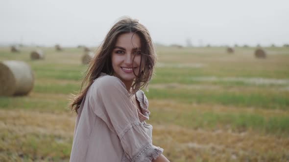 Girl in Dress with a Plaid in Hands Having Fun with Wind and Rejoicing at Camera