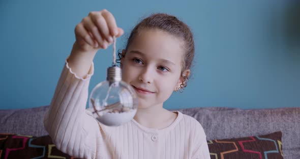 Portrait Funny Little Girl Smiling Child Looking at a Toy Ball are Sitting on Couch at Home Cute Kid