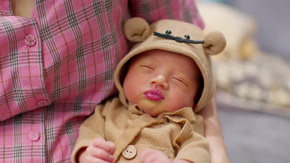 Adorable sleeping newborn baby relax in mother arm safety and comfortable