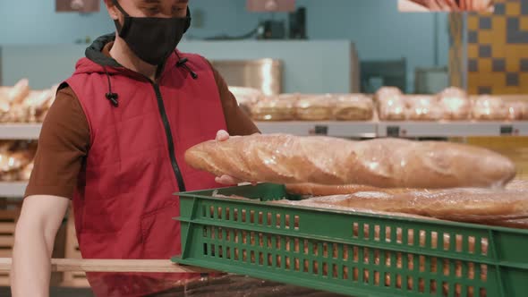 Male Worker Displaying Goods At Supermarket