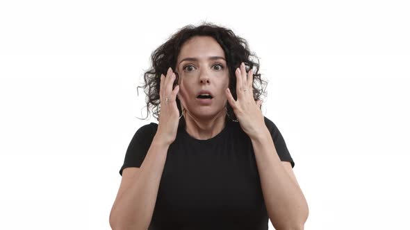 Cute Adult Woman with Curly Short Hair Jumping Startled and Gasping Looking Shocked at Camera