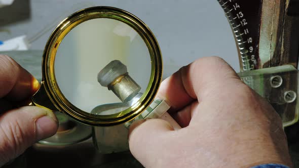 Jeweler Looks at Gemstone with Magnifying Glass