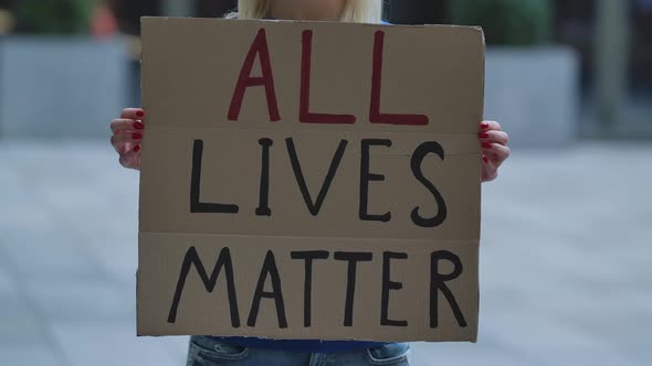 ALL LIVES MATTER on a Cardboard Poster in the Hands of White Female Protester Activist. Closeup of