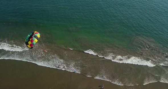 Parachute is landing on sandy Mexican Beach. Aerial view of extreme sport