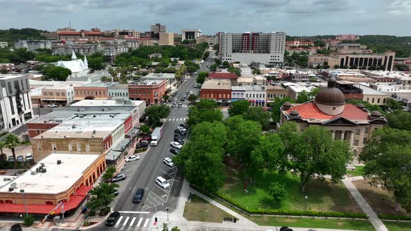 Wide aerial of downtown San Marcos Texas with Hays County Courthouse and TX State University in dist