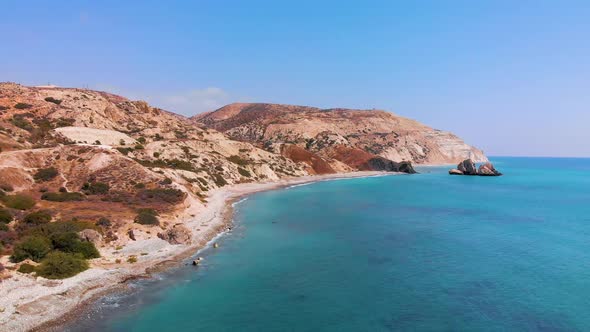 Slow aerial view flying along the coast of pafos towards Aphrodite's Rock on the coast of Paphos Cyp