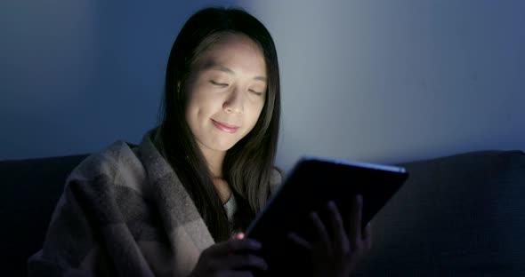 Woman use of tablet computer at night