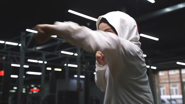 Muslim Woman in a Sports Hijab is Engaged in Boxing a Young Arab Woman is Doing Exercises in the Gym