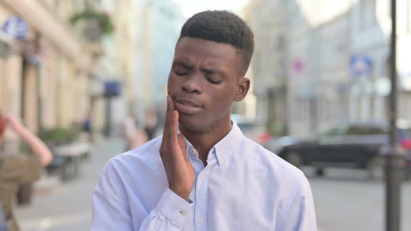 Sick African Man Having Toothache While Standing Outdoor