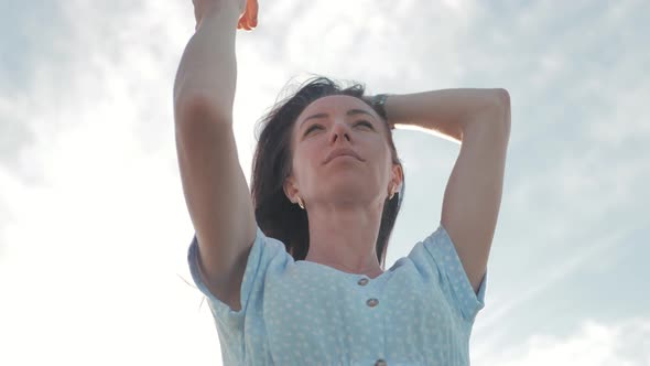 Young Woman Looking Up at Sunset Sky