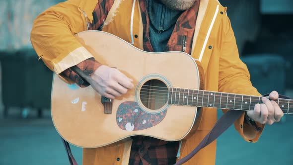 Guitar in the Hands of a Tramp Playing It