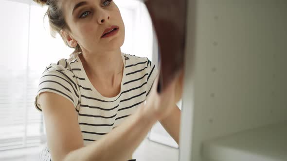 Tilt up video of young woman renovating old furniture. Shot with RED helium camera in 8K