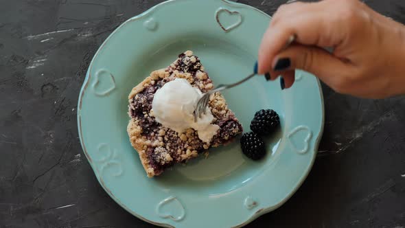 Piece of cake with blackberries and ice cream on a blue plate