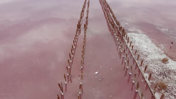 Old Pier on Pink Lake Medicinal Clay Ungraded on Sunset, Air Drone View