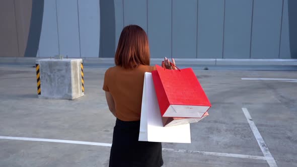 slow-motion of happy woman walking with shopping bags