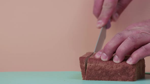 Closeup Male Hands Cut Black Bread in Slow Motion