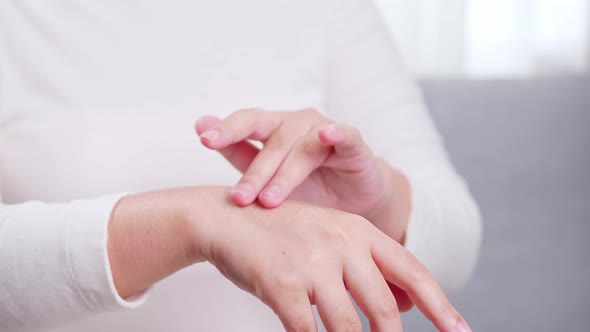 Detail of female hands applying moisturizing hand lotion