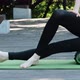 Girl on Yoga Mat Massages the Thigh Muscles with an MFR Roller - VideoHive Item for Sale