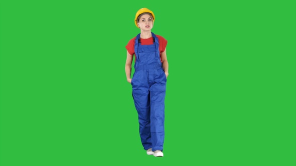 Woman builder with hands in pockets walking and telling