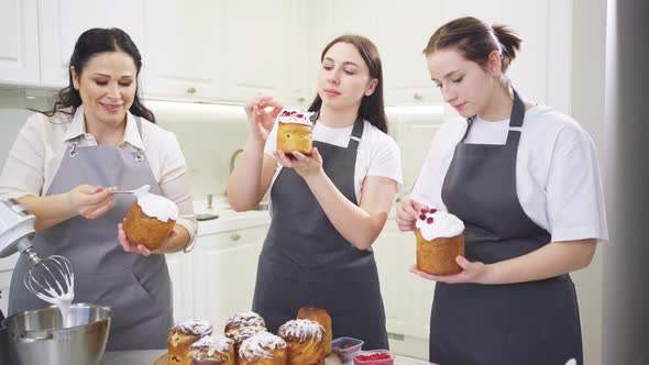 a Mother and Daughters Decorate Icing Dried Berries and Flowers Easter Cakes