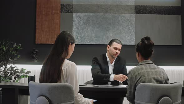 Male Advisor Salesman Talking with Women in Modern Office