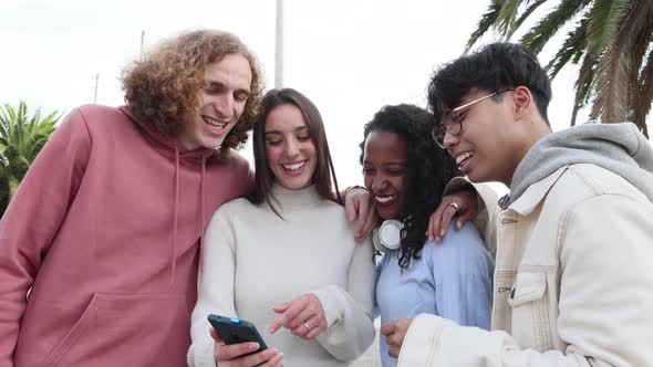 Millennial People Laughing Together While Watching Funny Content on Phone App