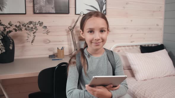 Cute Schoolgirl with Tablet Posing in her Room