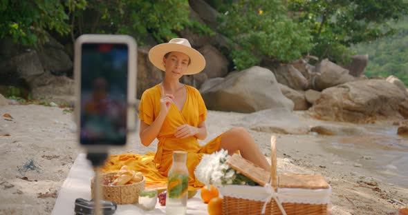 Woman in a Yellow Outfit Filming for Her Vblog Streaming Online From the Beach for Her Followers