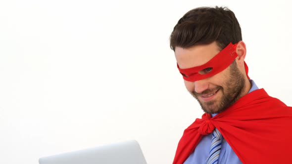 Businessman using laptop pretending to be a super hero