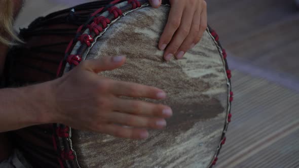 Male hands playing bongo drums, close up