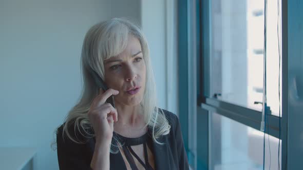 Focused Middle Aged Business Lady Standing Near Window