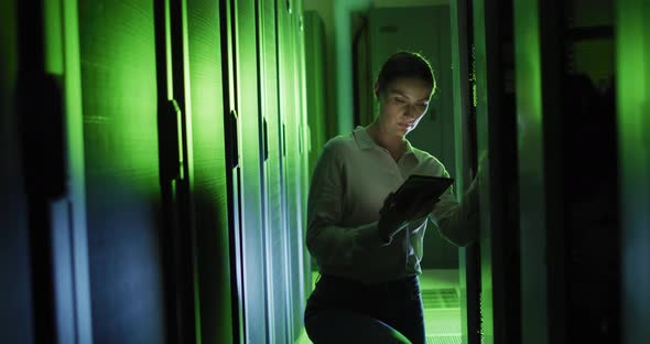 Caucasian female it technician using tablet checking computer server