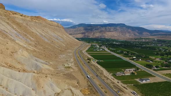 Aerial Against Sandy Mountains and Highway Next to Palisade Peach Farms in Colorado