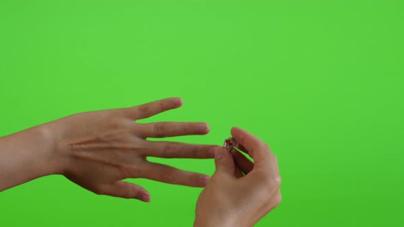 Displaying and trying silver ring greenscreen display 4K 2160p UltraHD footage - Woman holding a  ri