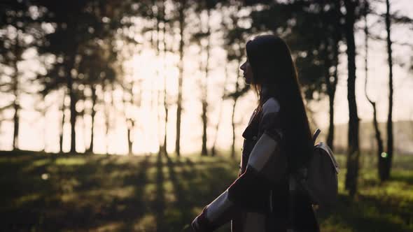 Beautiful Young Hipster Woman in a Shirt Walking Through a Picturesque Pine Forest