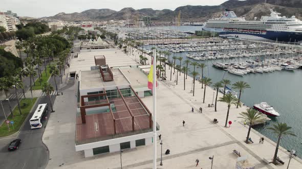 Aerial orbit around flagpole with Spanish flag, Cartagena port square