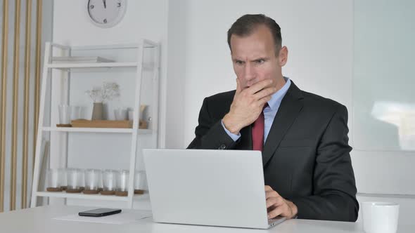 Shocked Middle Aged Businessman Working on Laptop, Astonished