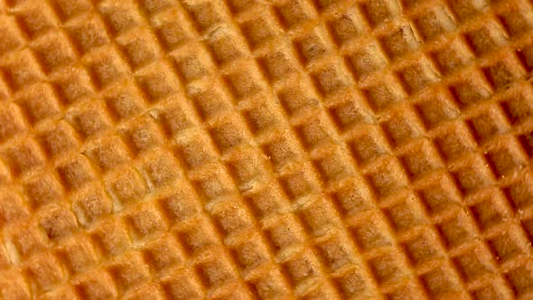 Close-up waffles move in a circular rotation. Texture of waffle cone background