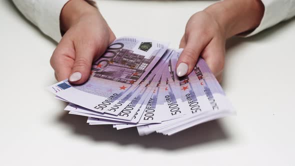 Businesswoman Flipping Through the Bills in a Fan of Money Rich Woman Holding a Stack of 500 Euro in