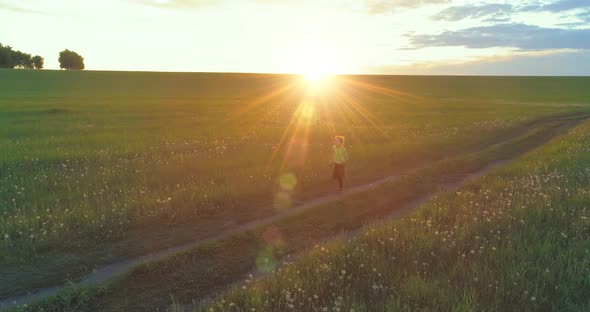 Sporty Child Runs Through a Green Wheat Field