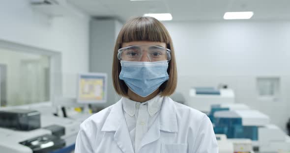 Portrait of Young Woman in Protective Mask and Googles Looking To Camera