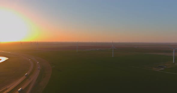 Road Leading to view of the Texas wind turbine farms in the beautiful sky during sunset showing