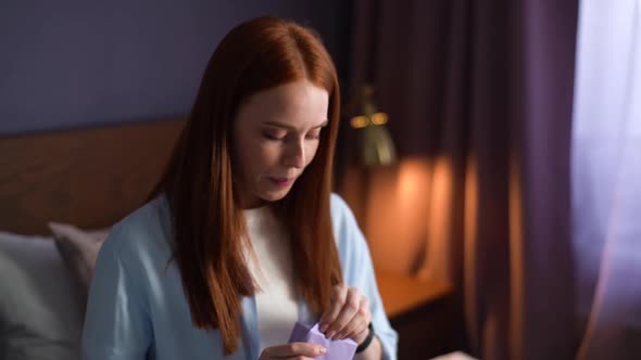 Close-up Face of Happy Excited Young Woman Opening Gift Box with Present at Cozy Living Room