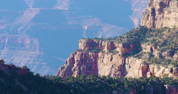 Overlooking the North Face of the Grand Canyon, a butte juts out over the chasm below. The air is ha