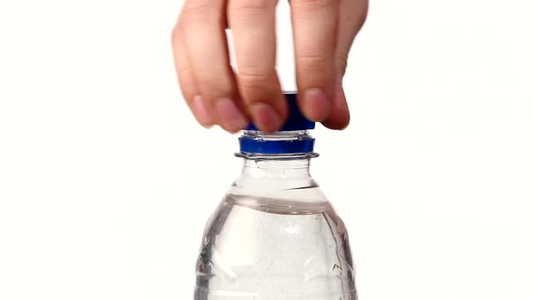 Hands Opening a Blue Bottle of Fresh Water on White, Slow Motion, Splash, Spray, Bubbles