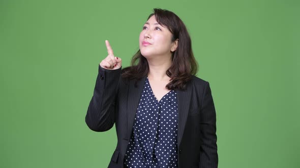 Mature Beautiful Asian Businesswoman Thinking While Pointing Finger Up